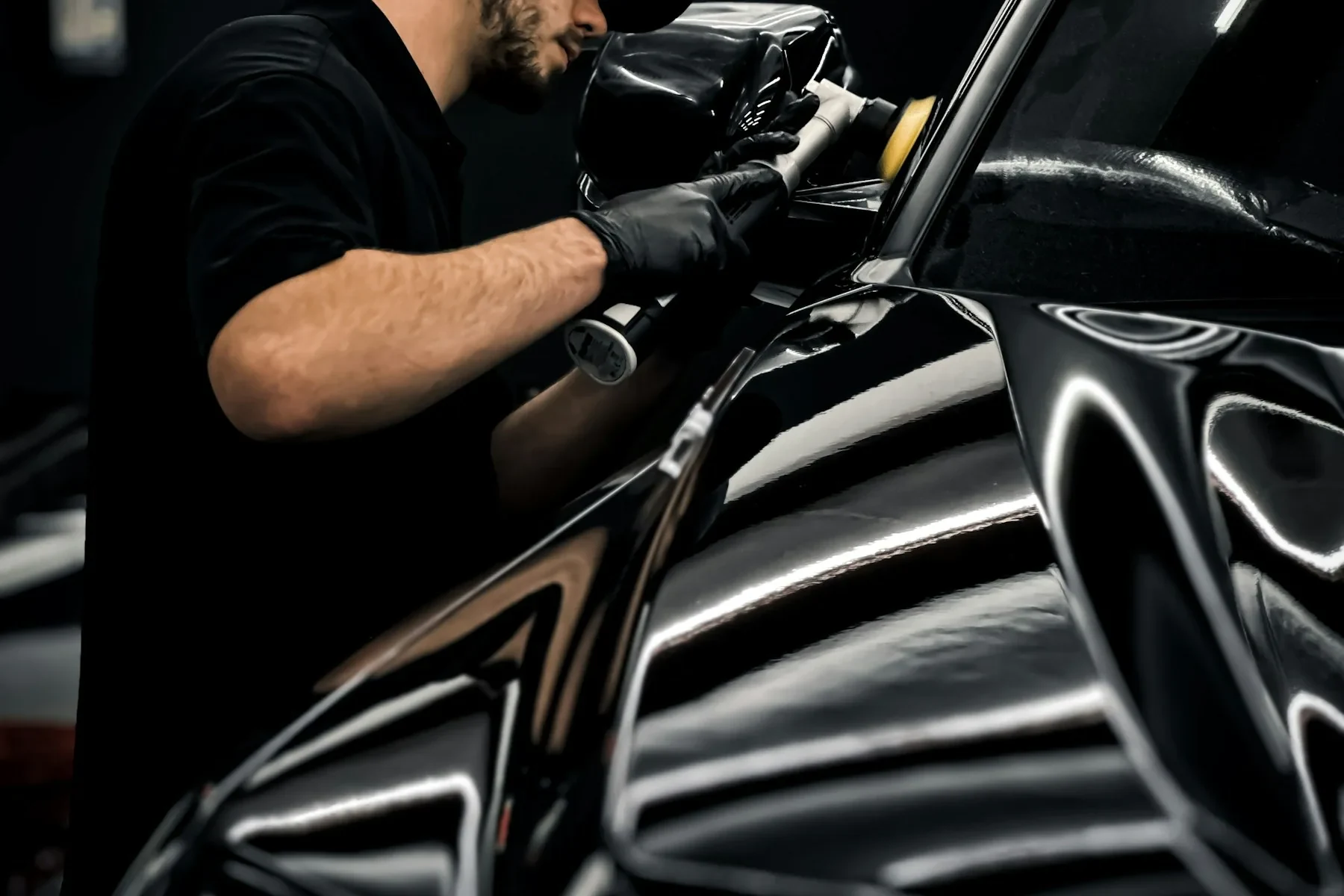 Owner detailer hand-finishing a vehicle