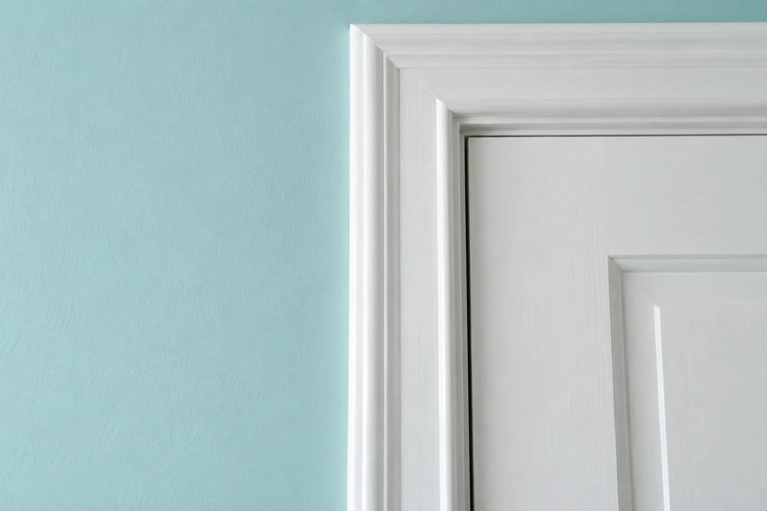 Crisp junction between an aqua wall and white painted trim